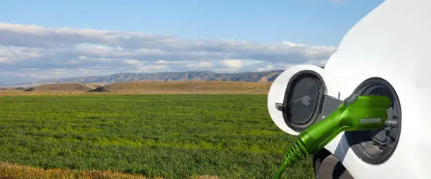 Close up view of Electric Car charging and field background