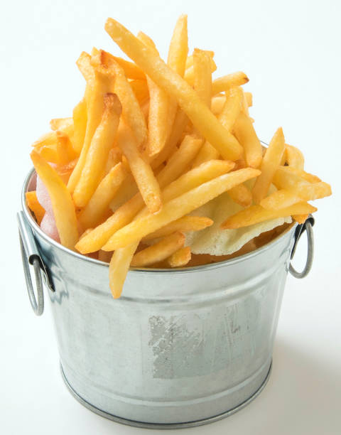 istock Fried potatoes chips in iron bowl on white background 671543932