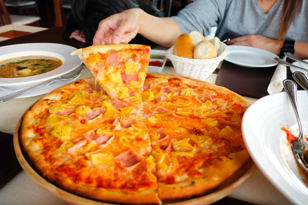 istock hand picked Hawaiian pizza from a wooden tray 671550206