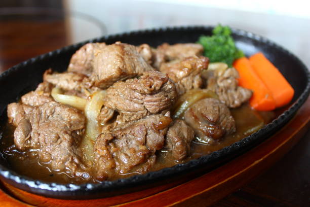 istock Sauteed beef with carrot on black platter 671554736