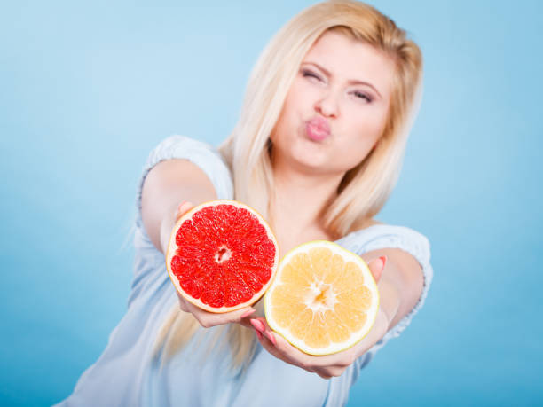 istock Woman holds grapefruit citrus fruit in hands 671556916