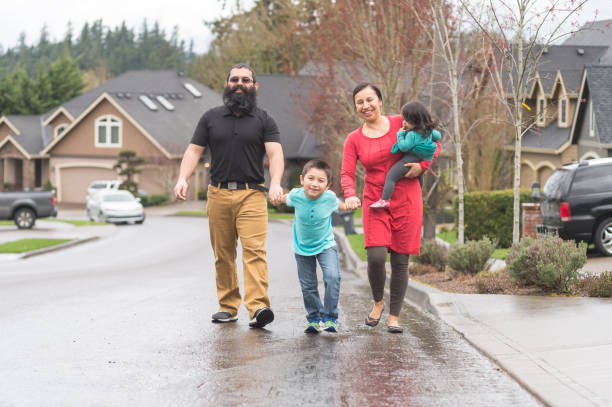 deux parents d’amérindiennes et leurs enfants faire une promenade familiale par le biais de leur quartier de banlieue - native habitat photos et images de collection