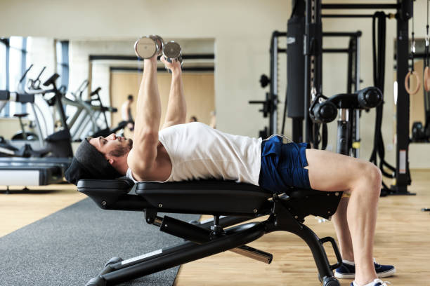 istock Young man workout with dumbbells in gym 671565426
