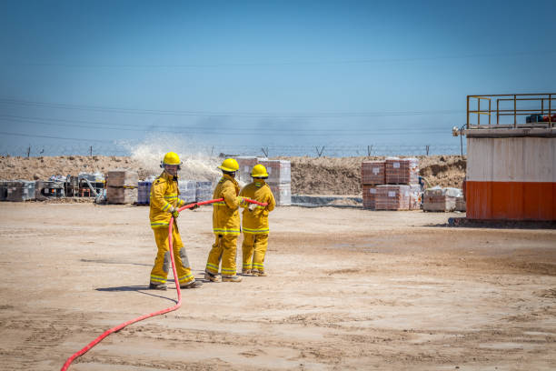 fireman with uniform helmet and respirator with oxygen cylinders during the fire extinguishing of the car after the road accident