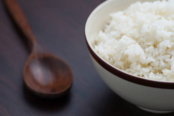 istock Thai rice in bowl with wooden spoon on table 671568288