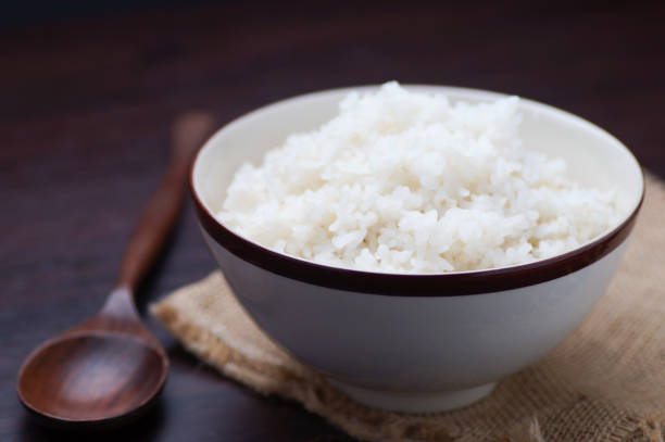 istock Thai rice in bowl with wooden spoon on table 671571092