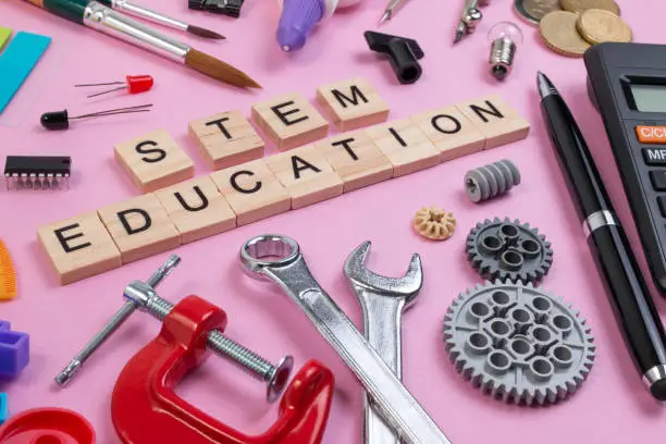 Photo of School equipment with word STEM Education over pink background in education STEM concept.