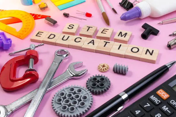 Photo of School equipment with word STEM Education over pink background in education STEM concept.