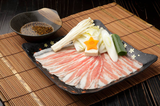 istock Fresh sliced pork on black platter with mushroom, onion  and sauce 671579772