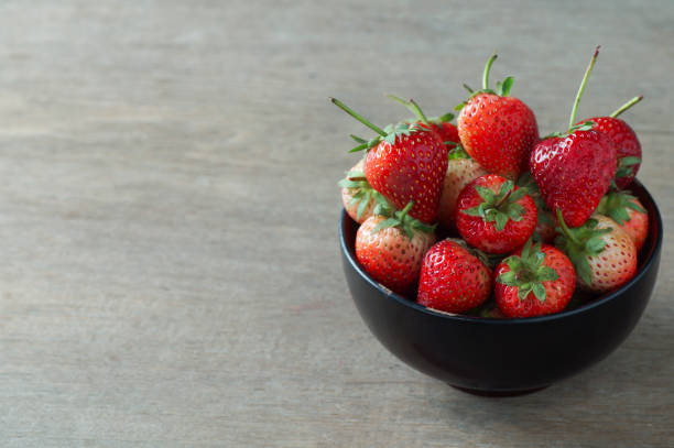 istock Fresh strawberries in bowl  on wooden table and copy space 671582828