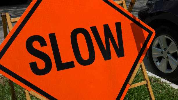 istock Slow down red banner traffic sign on the road. 671590216