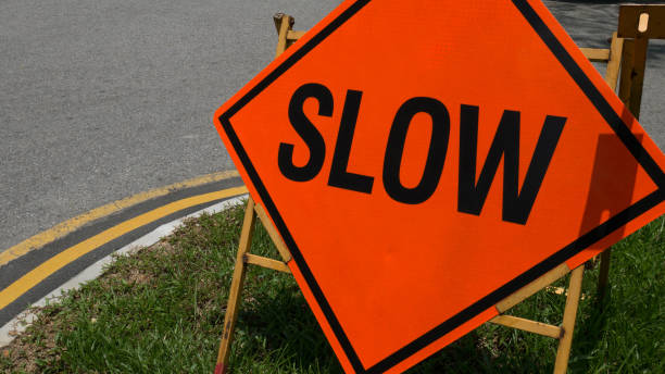 Slow down red banner traffic sign on the road.