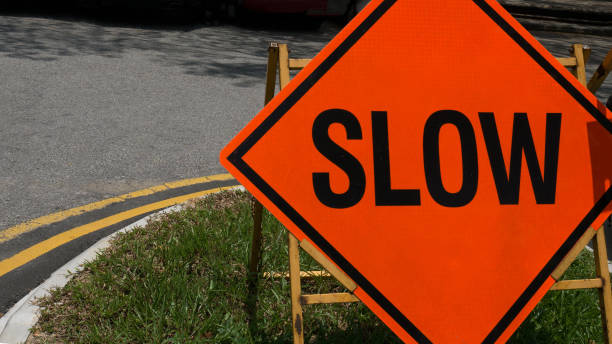 istock Slow down red banner traffic sign on the road. 671590238