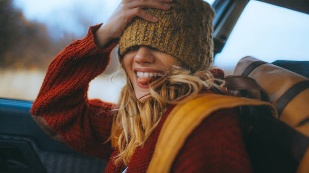 Happy girl Young, happy, smiling girl in a car, covered eyes with a cap and making crazy faces hipster car stock pictures, royalty-free photos & images