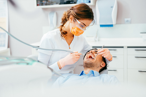 Female dentist working on patient's teeth.