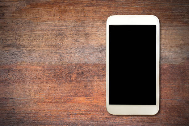 istock White smart phone on wooden desk 671607998