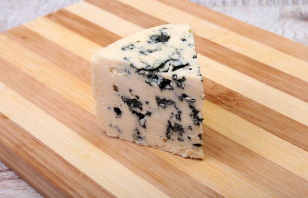 istock Plate with Tasty blue cheese on wooden table 671614376