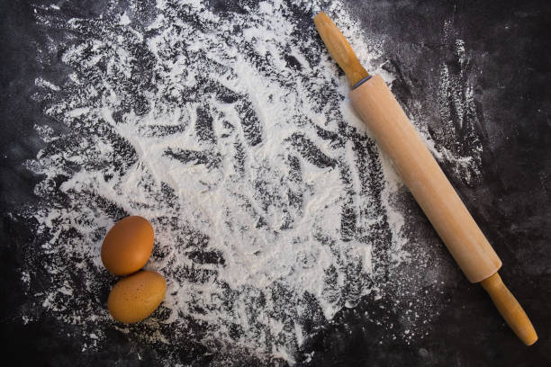 istock Baking background with the rolling pin with flour. On the dark table. Free space for text . Top view 671626484