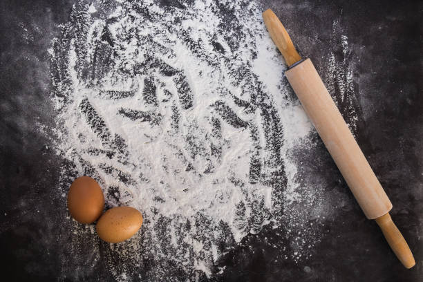 istock Baking background with the rolling pin with flour. On the dark table. Free space for text . Top view 671631332
