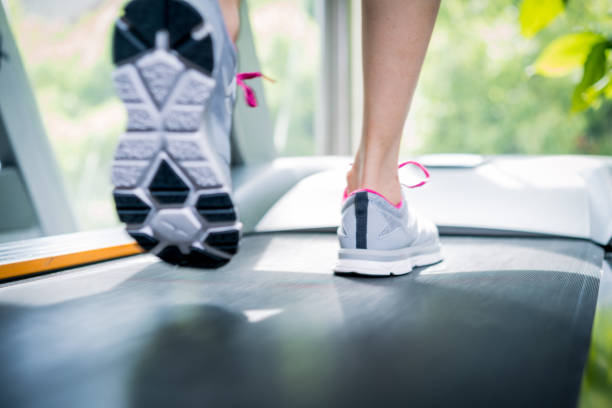 istock Girl running on treadmills in a gym 671640866