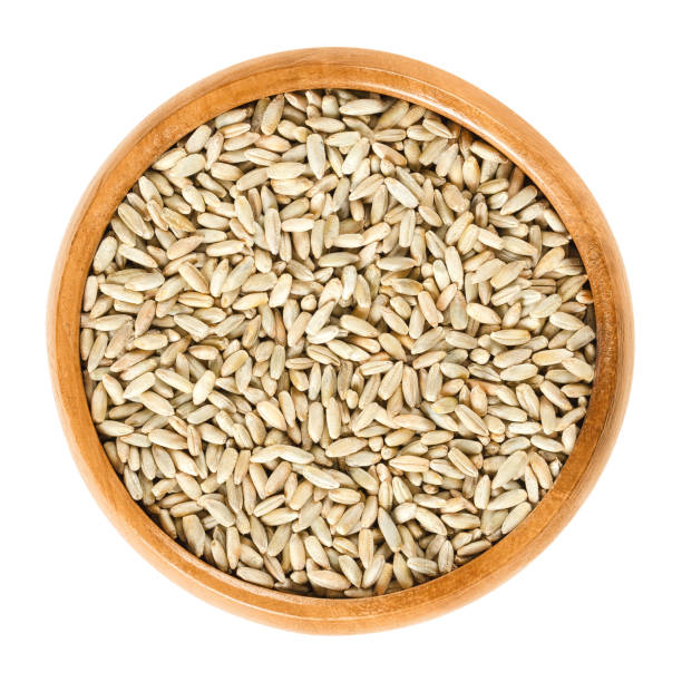 istock Rye grains in wooden bowl over white 671641366