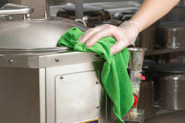 istock Hand in protective glove with rag cleaning kitchen equipment in the professional kitchen. Stainless steel surface. Early spring cleaning or regular clean up. 671652782
