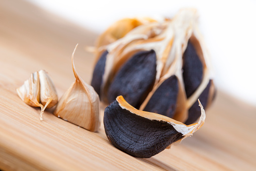 Peeled black garlic on extreme close-up. nice detail in the garlic texture, nice color.