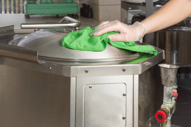 istock Hand in protective glove with rag cleaning kitchen equipment in the professional kitchen. Stainless steel surface. Early spring cleaning or regular clean up. 671655326
