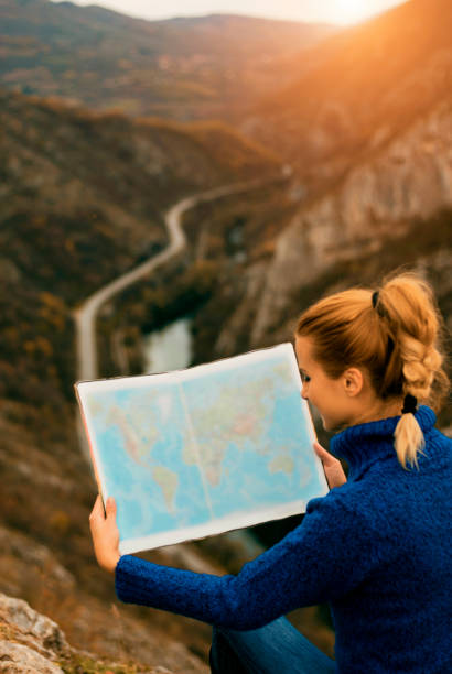 istock Woman with map on the mountain 671659258