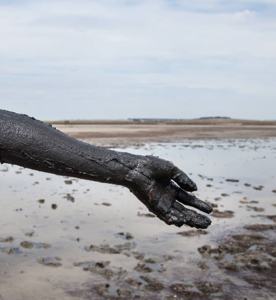 Woman's hand smeared with black healing mud.