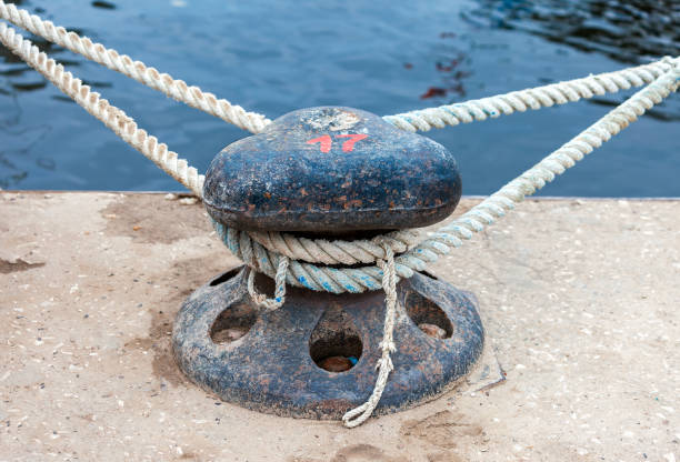 istock Mooring metal bollard with a fixed rope at the pier 671676640