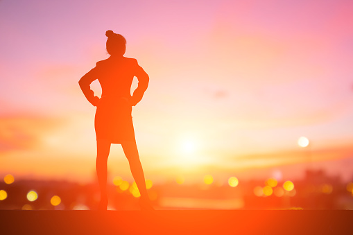 silhouette of business woman look somewhere with sunset