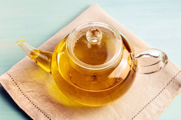 istock Teapot full of tea on teal texture with copyspace 671712450
