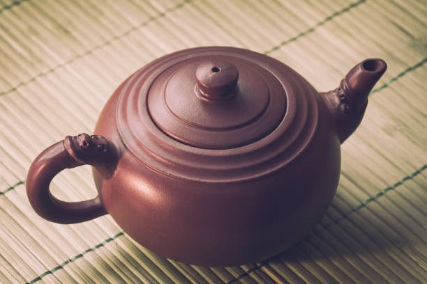 istock Close-up ceramic teapot on green bamboo background. Retro filter. 671712486