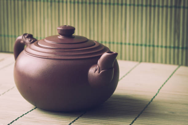 istock Close-up ceramic teapot on green bamboo background. Retro filter. 671712868