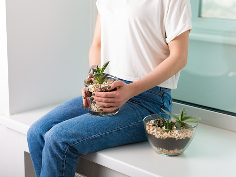 Woman sitting near flower pots with succulents