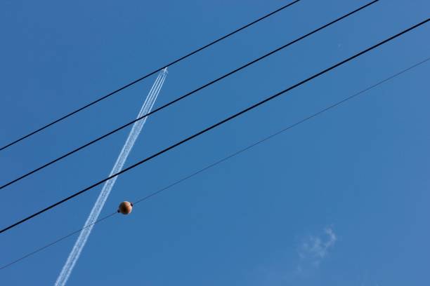 istock Airplane in the sky with high tension wires (1) 671730212
