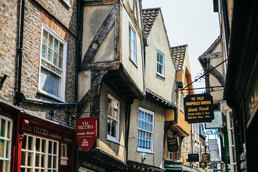 York, UK - 24 June 2016: The Shambles are famous for their uneven shops been built along this narrow street.