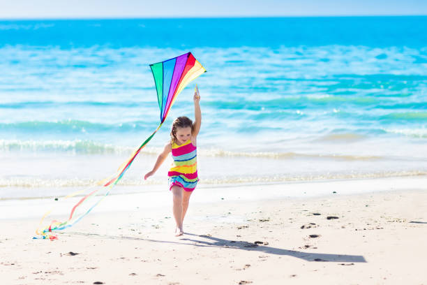 istock Child flying kite on tropical beach 671730650