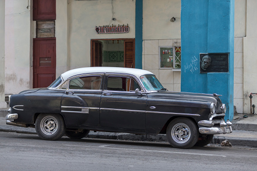 Havana, Cuba-January 28, 2017: One black vintage car park on the street. Residential building on the background.