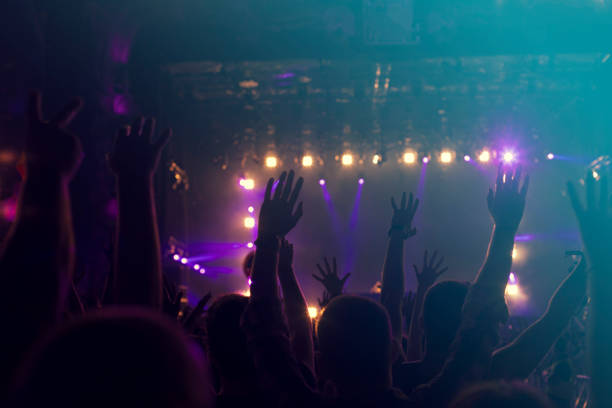 istock crowd, happy people enjoying rock concert, raised up hands 671738130