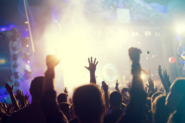 istock crowd, happy people enjoying rock concert, raised up hands 671738136
