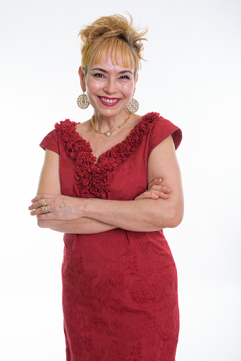 Studio shot of happy senior Asian businesswoman smiling with arms crossed against white background vertical shot