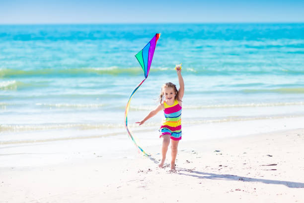 istock Child flying kite on tropical beach 671741156