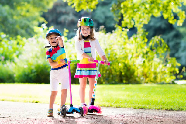 istock Kids riding scooter in summer park. 671741190