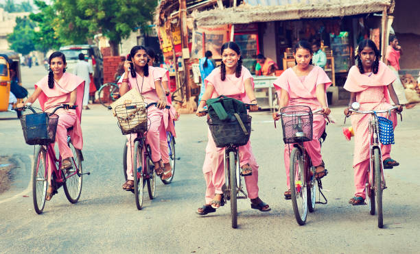 Group of young girls, dressed in school uniform going home on the bicycles. Tiruchirappalli,Tamil Nadu state,India. Group of young girls, dressed in indigenous style school uniform, going home on the bicycles after lessons.  From series of pictures: "casual street portraits". kapaleeswarar temple photos stock pictures, royalty-free photos & images