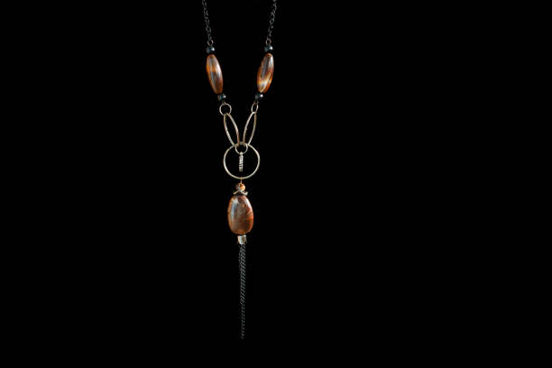 Old necklace with brown stones isolated on black
