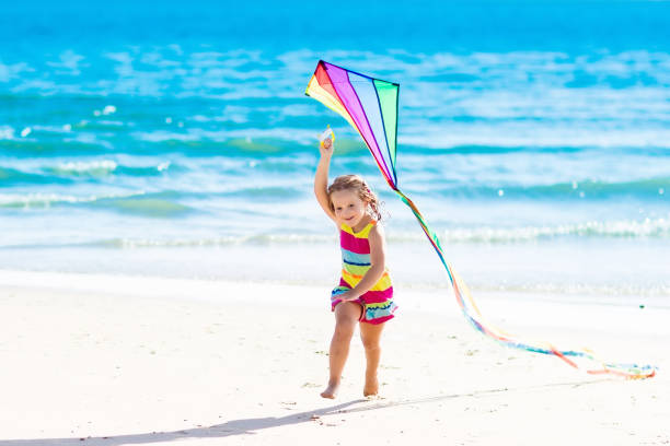 istock Child flying kite on tropical beach 671750728