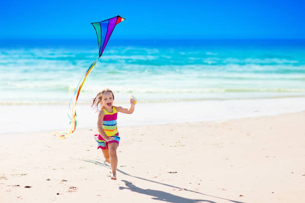 istock Child flying kite on tropical beach 671753814
