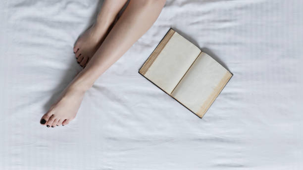 istock Book by the woman legs 671754192